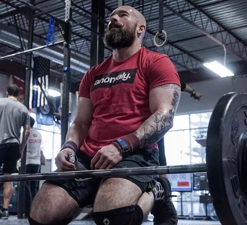A masters athlete resting on a barbell